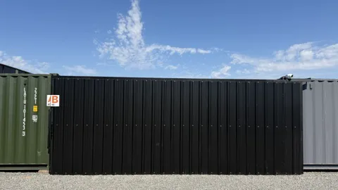 Frente de un container negro con una cámara de seguridad sobre el techo en el predio de Tigre